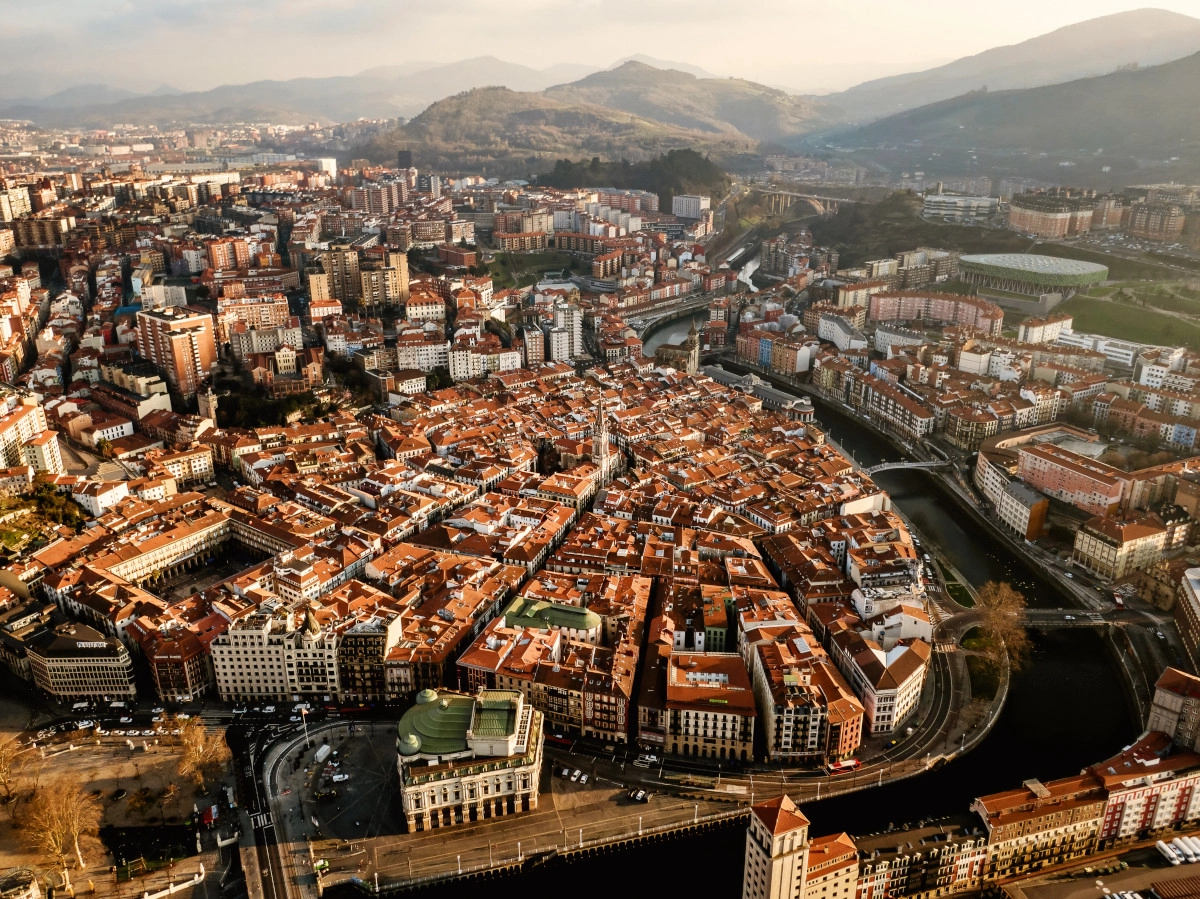 Vista panorámica de Bilbao con el Museo Guggenheim y la Ría, mostrando el dinamismo y la modernidad de la ciudad.